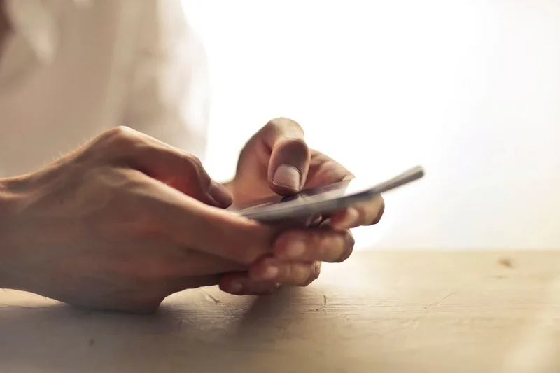 Manos utilizando un teléfono móvil para contactar de forma sencilla